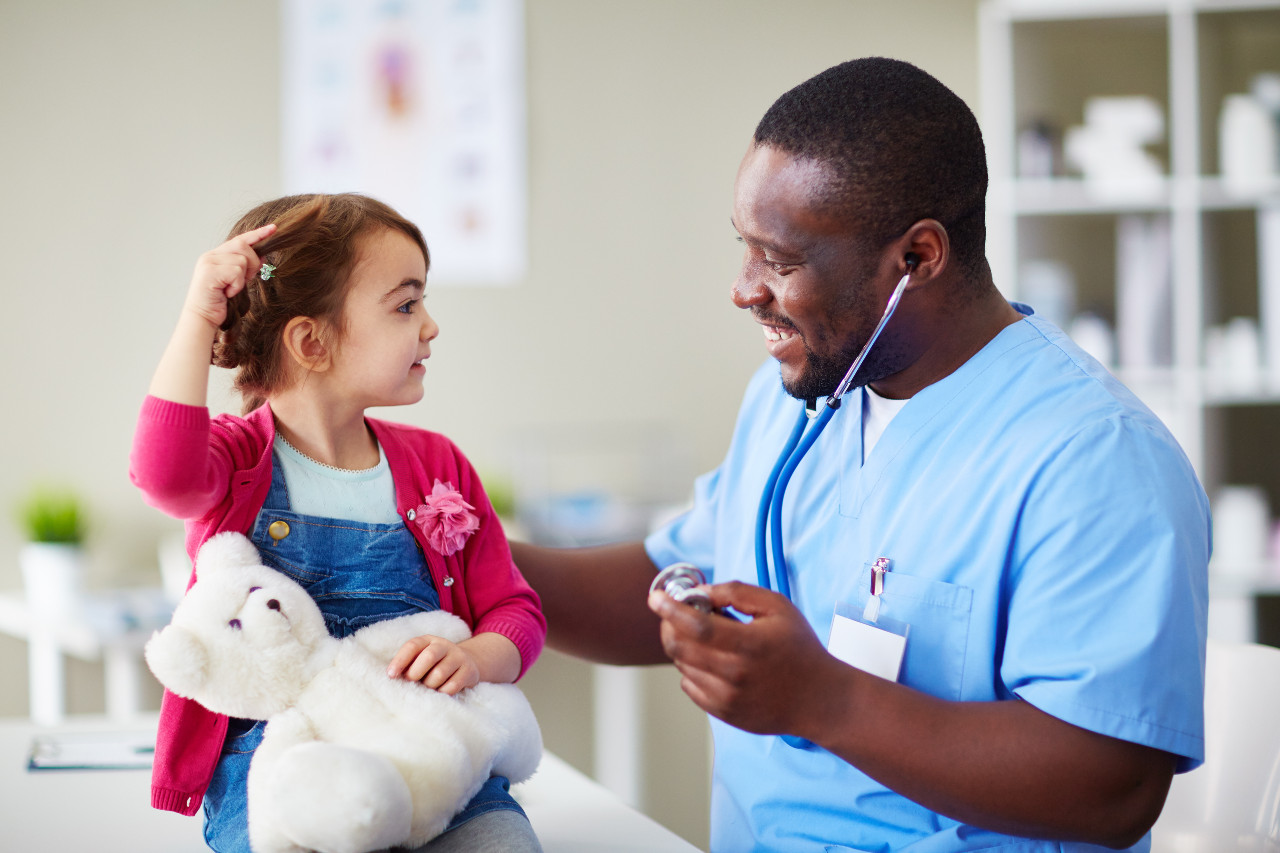 a pediatrician with a young girl